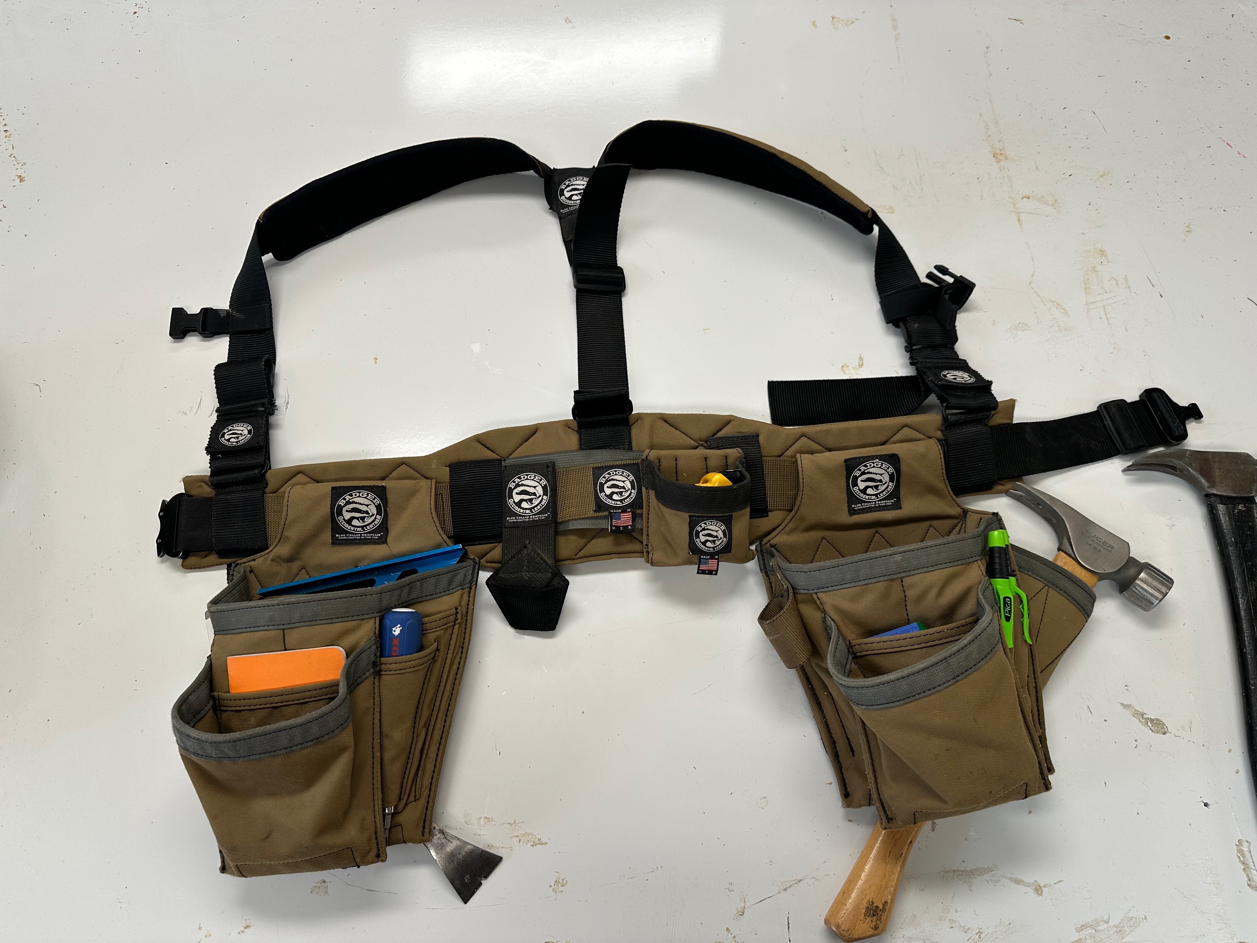 Badger Trimmer B12 tool belt with its two compact pouches and suspenders arranged on a workbench.