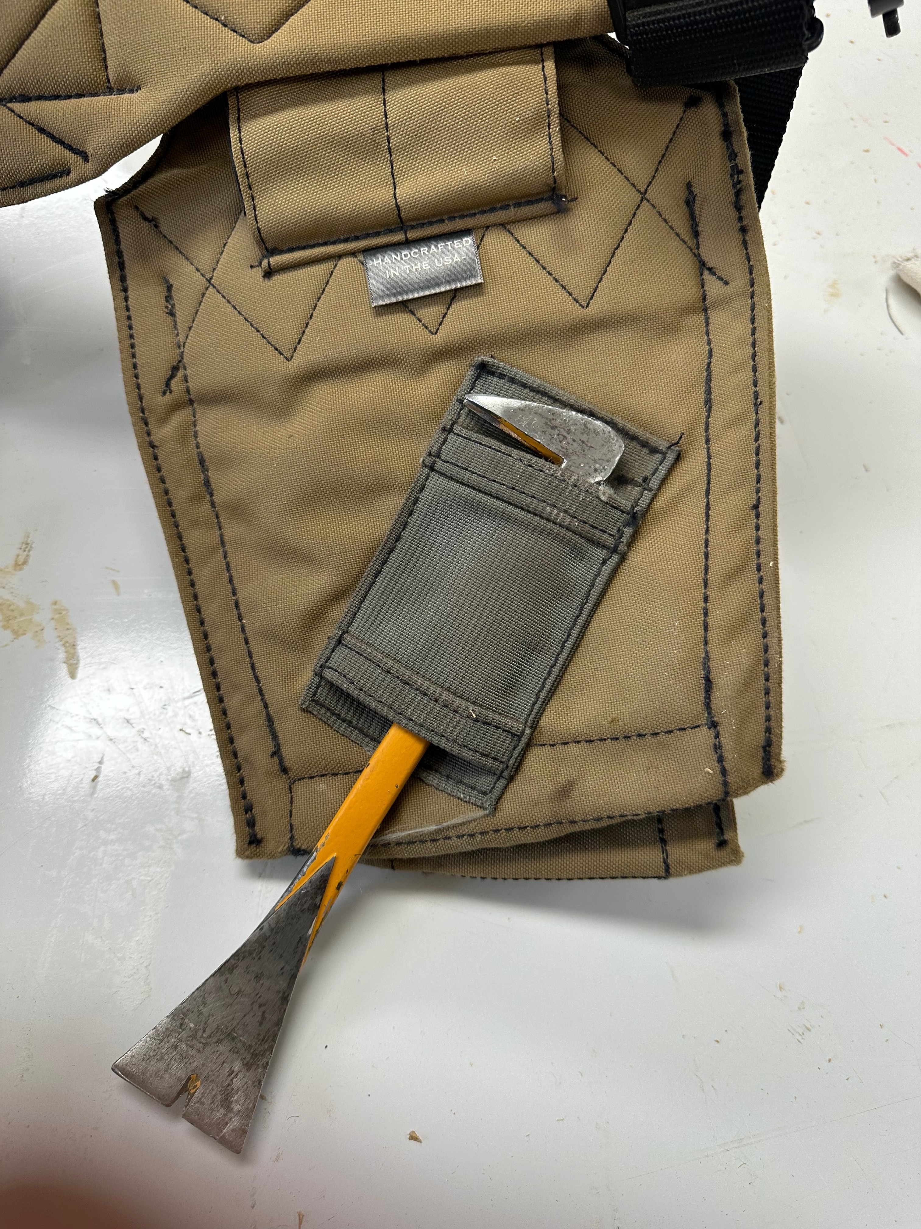 Worn half-inch chisel stored in the cat’s-paw sleeve behind a Badger pouch.