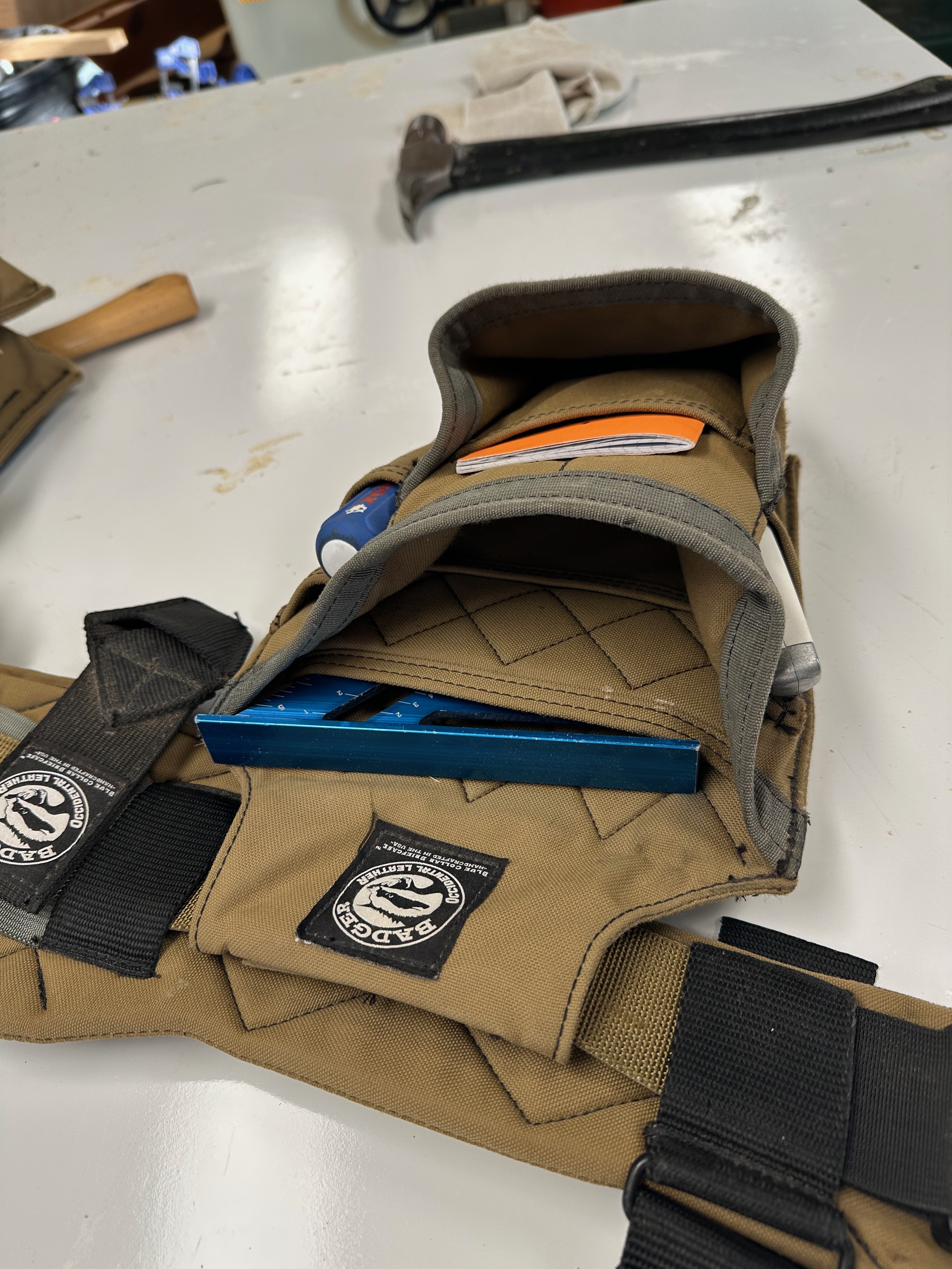 Badger fastener pouch and center-mounted tape holster with a compact tape measure.