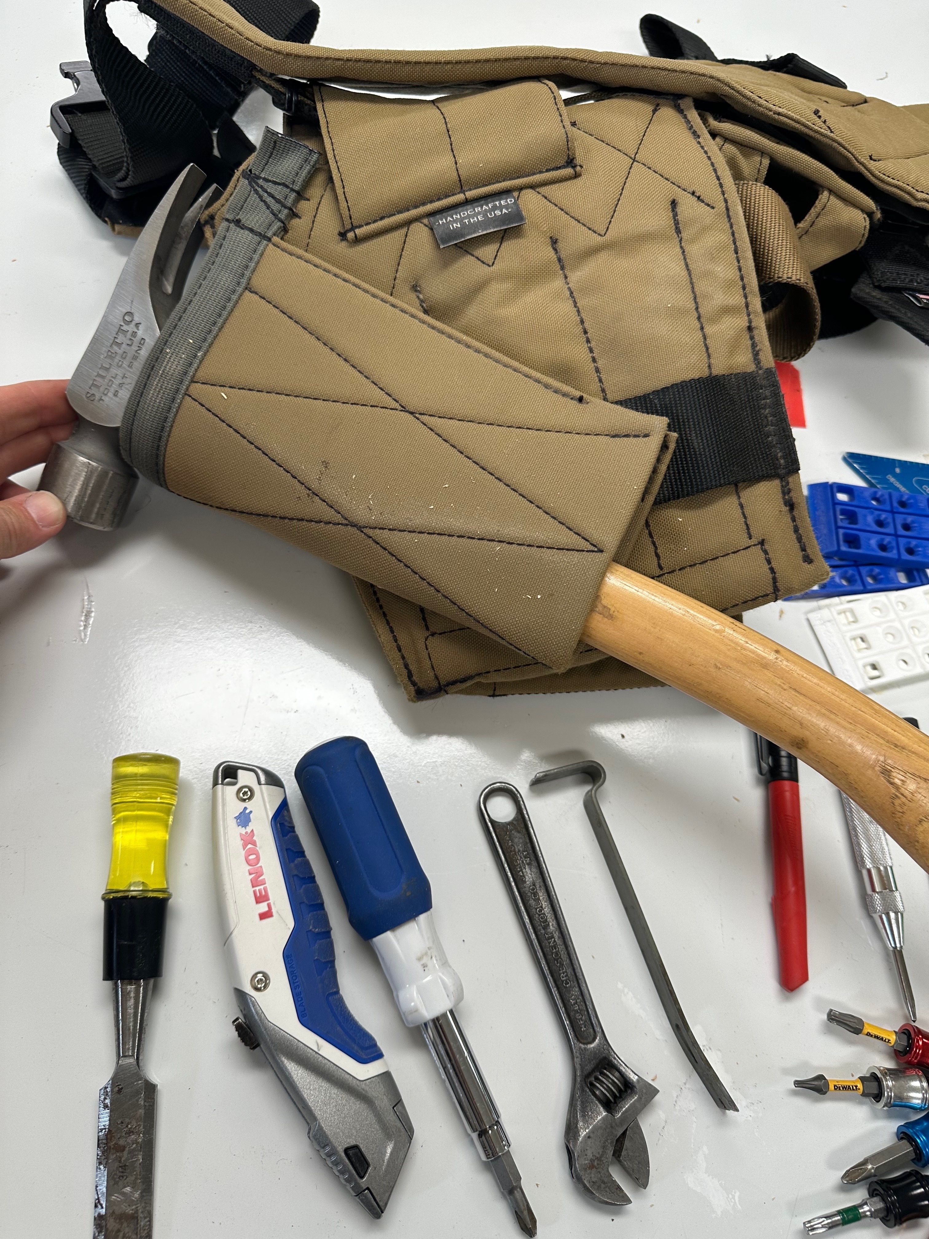 Hammer being placed through the reinforced sleeve on the back of a Badger tool pouch.